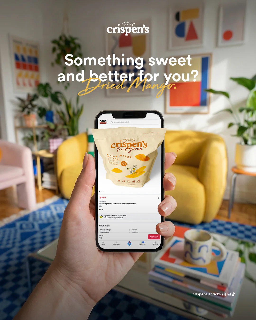 Crispen’s dried mango snack displayed on a smartphone in a colorful living room