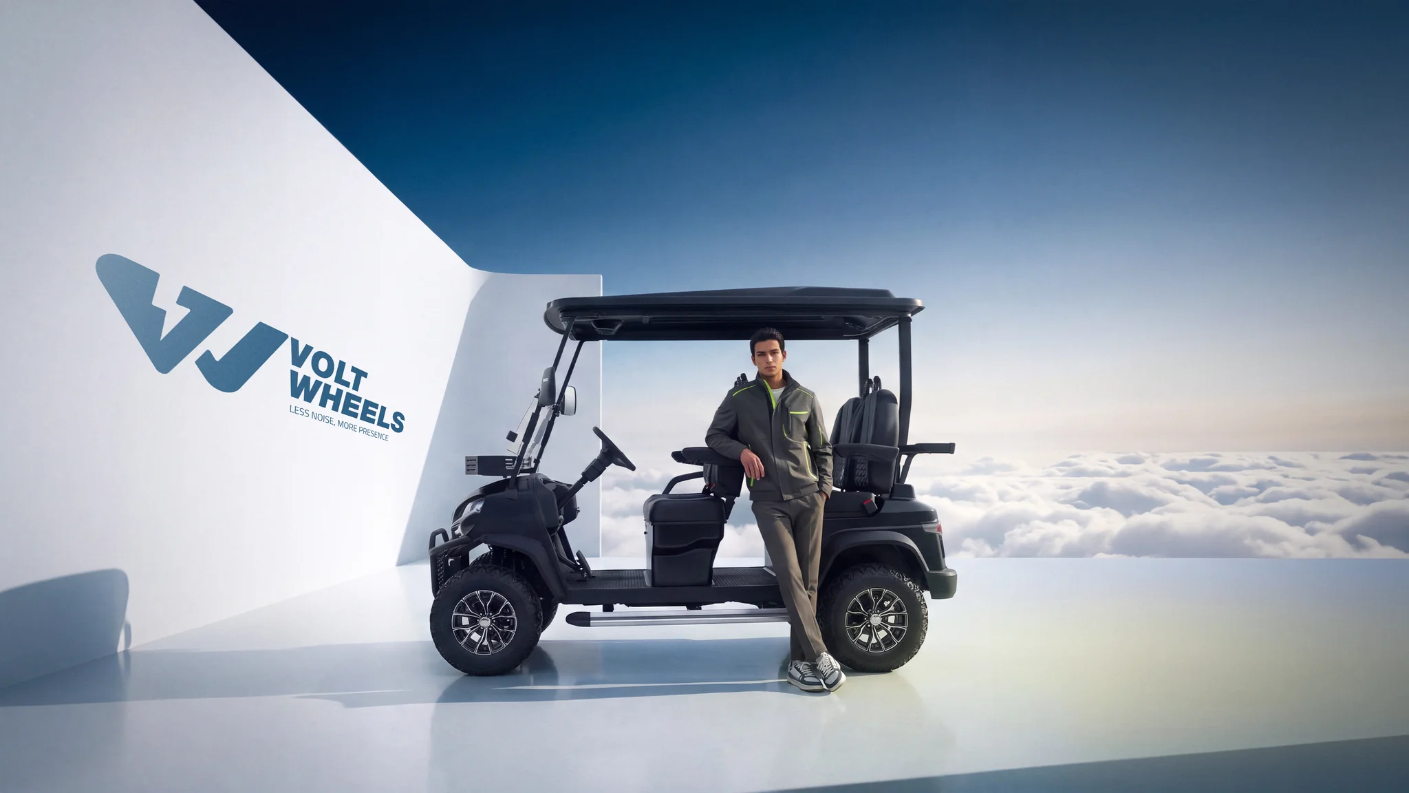 Volt Wheels key visual: a black electric golf cart and a man in a grey jacket on a white platform above the clouds, beside the brand wall